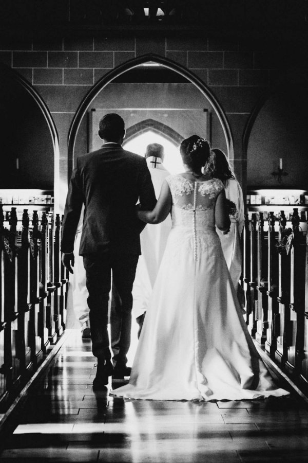 Brautpaar beim Auszug nach der kirchlichen Trauung aus der St. Ägidius Kirche in Höpfingen. Das Bild ist in schwarz-weiß mit einem harten Kontrast.