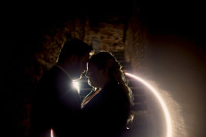 Silhouette eines Brautpaars in einem innigen Moment. Im Hintergrund sind Mauern des Eberbacher Schlosses zu sehen. 