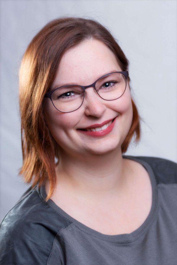 Bewerbungsfotos einer Frau mit schulterlangen Haaren und Brille vor einem weißen Hintergrund.